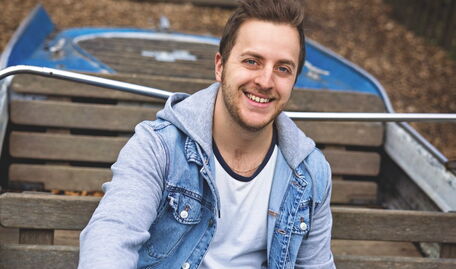 Oliver Rupp sitzt in einem kleinen Boot und hält das Steuer.