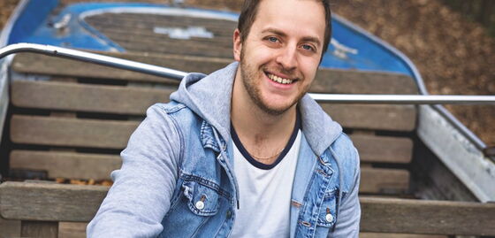 Oliver Rupp sitzt in einem kleinen Boot und hält das Steuer.